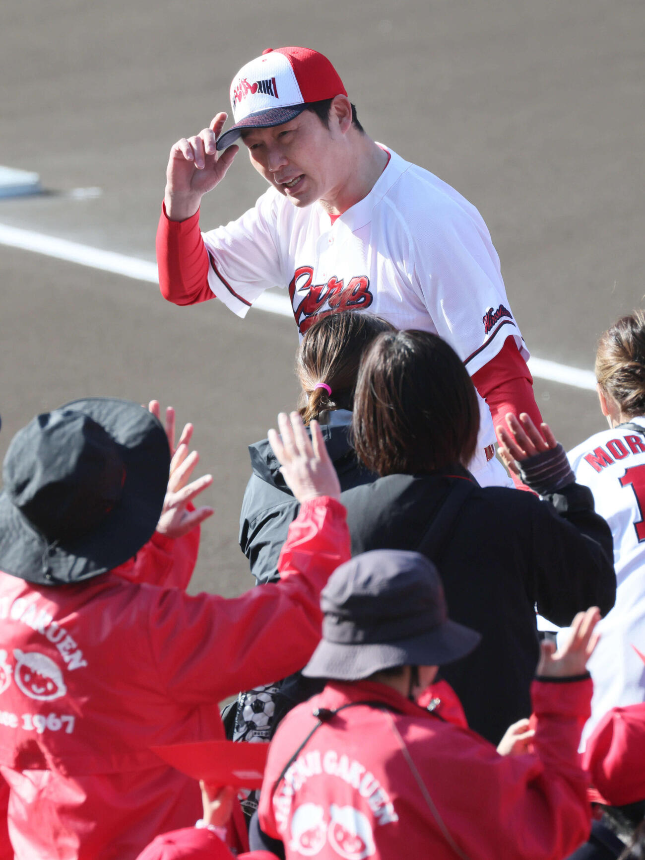 日南キャンプ歓迎式を終え、会釈しながら引き揚げる広島新井監督（撮影・加藤孝規）