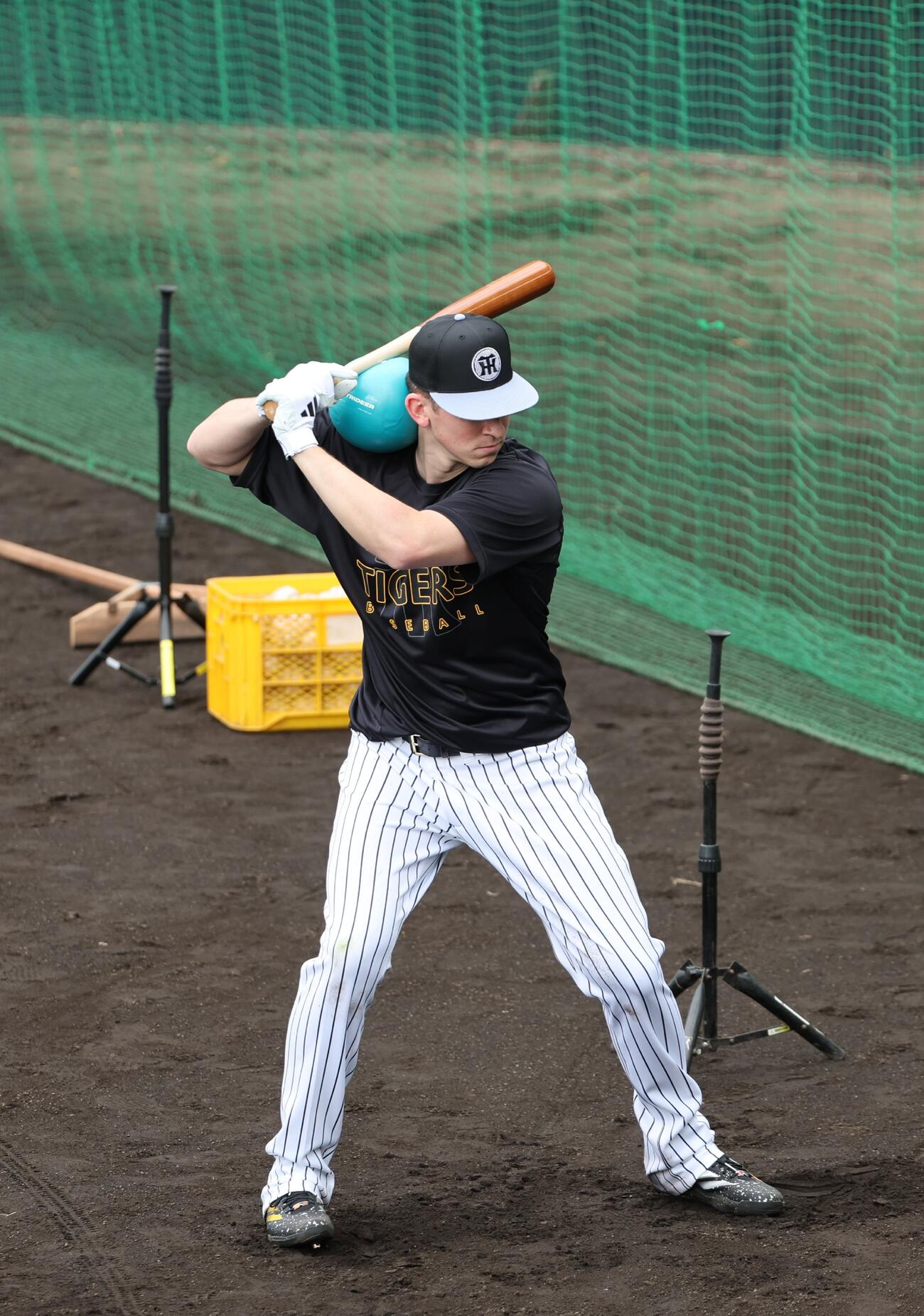 肩にメディシンボールを乗せてティー打撃を行う阪神ディベイニー（撮影・西尾就之）