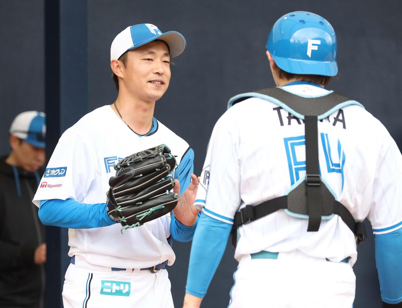 ブルペンで投球後、田宮（右）と話す日本ハム島本（撮影・黒川智章）