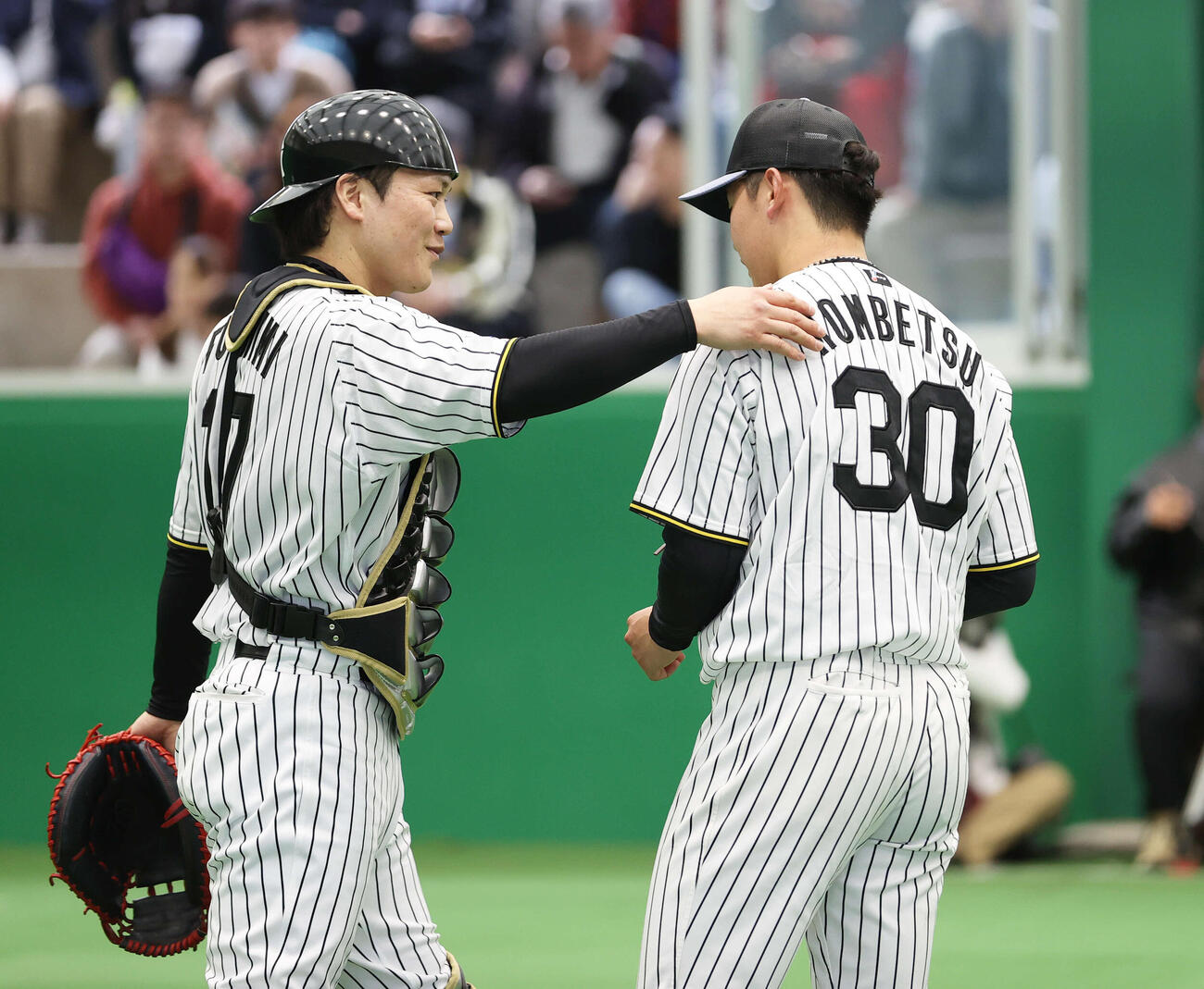 ブルペンで投球を終えた阪神門別（右）のと話をする阪神伏見（撮影・上山淳一）