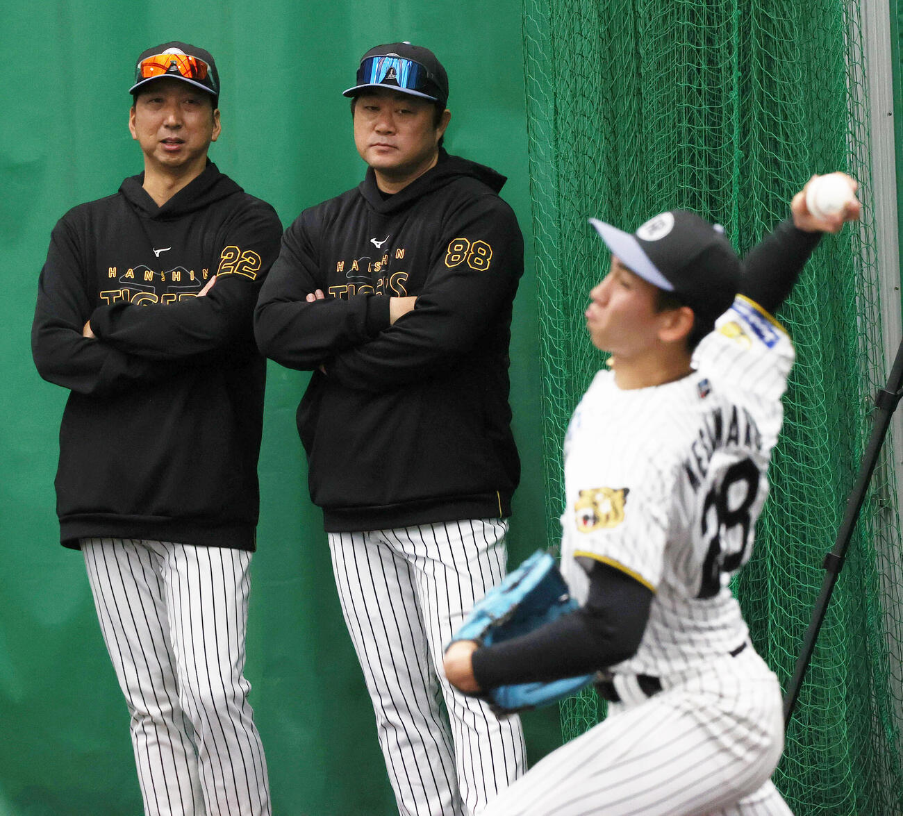 ブルペンで投げ込む阪神今朝丸（手前）を見つめる藤川監督（左）と安藤投手チーフコーチ（撮影・上山淳一）