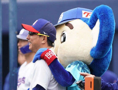 川崎臨時コーチ兼選手（左）はドアラから肩をもまれ笑顔を見せる（撮影・森本幸一）