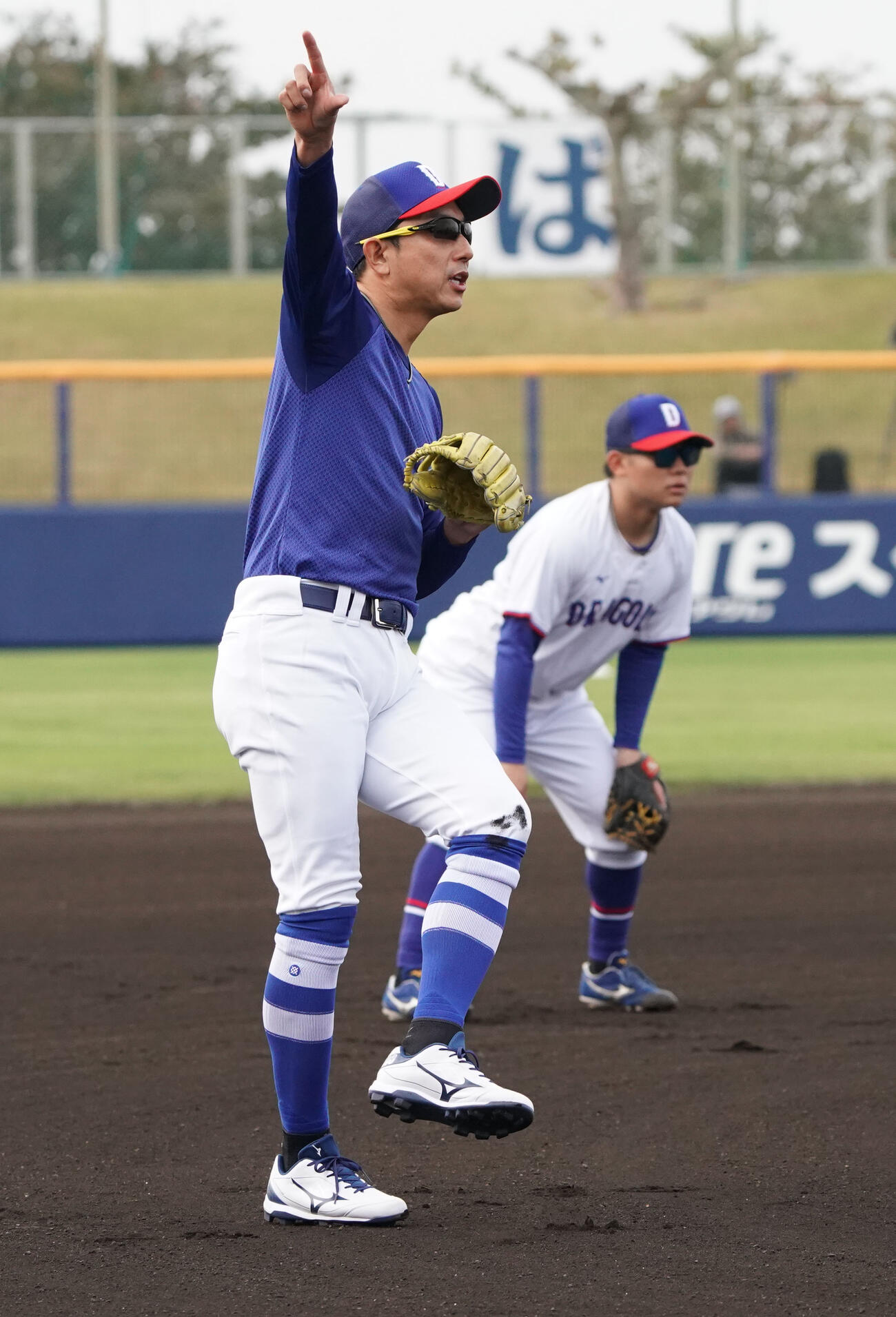 川崎臨時コーチ兼選手（左）は球場に流れる曲に合わせて体を動かす（撮影・森本幸一）