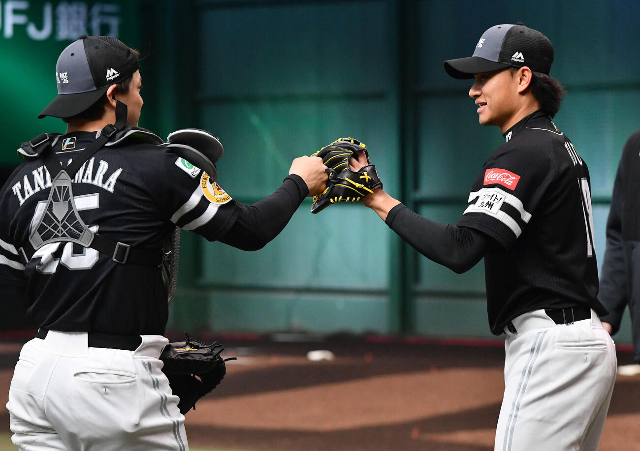 ブルペンでの投球を終えたソフトバンク徐（右）は谷川原とタッチを交わす（撮影・岩下翔太）