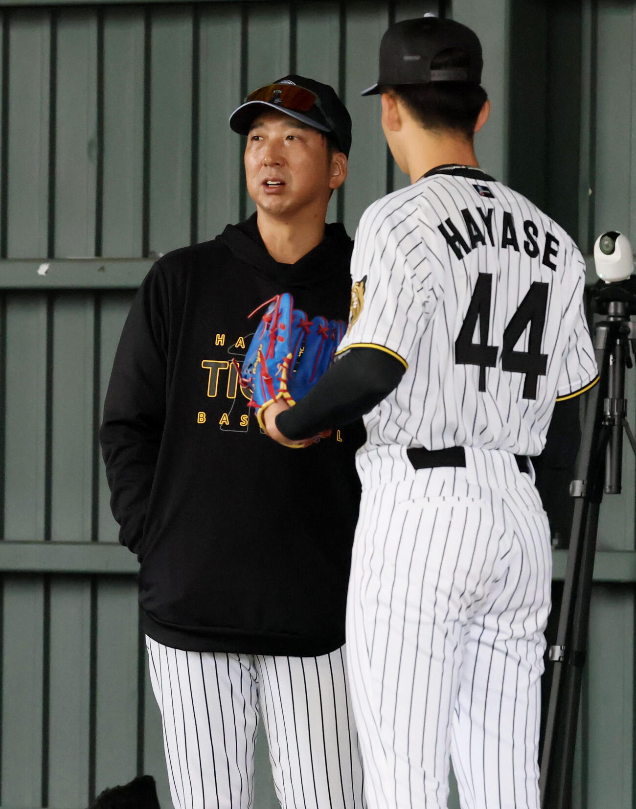 ブルペンで投球練習する阪神早瀬（右）に声をかける藤川監督（撮影・加藤哉）