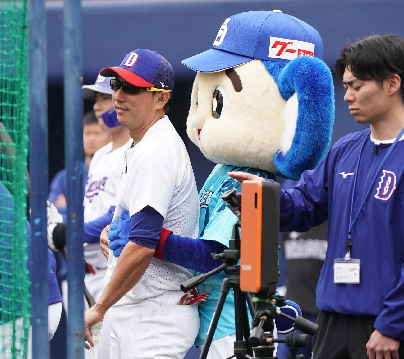 川崎臨時コーチ兼選手（左）はドアラからバックハグされる（撮影・森本幸一）