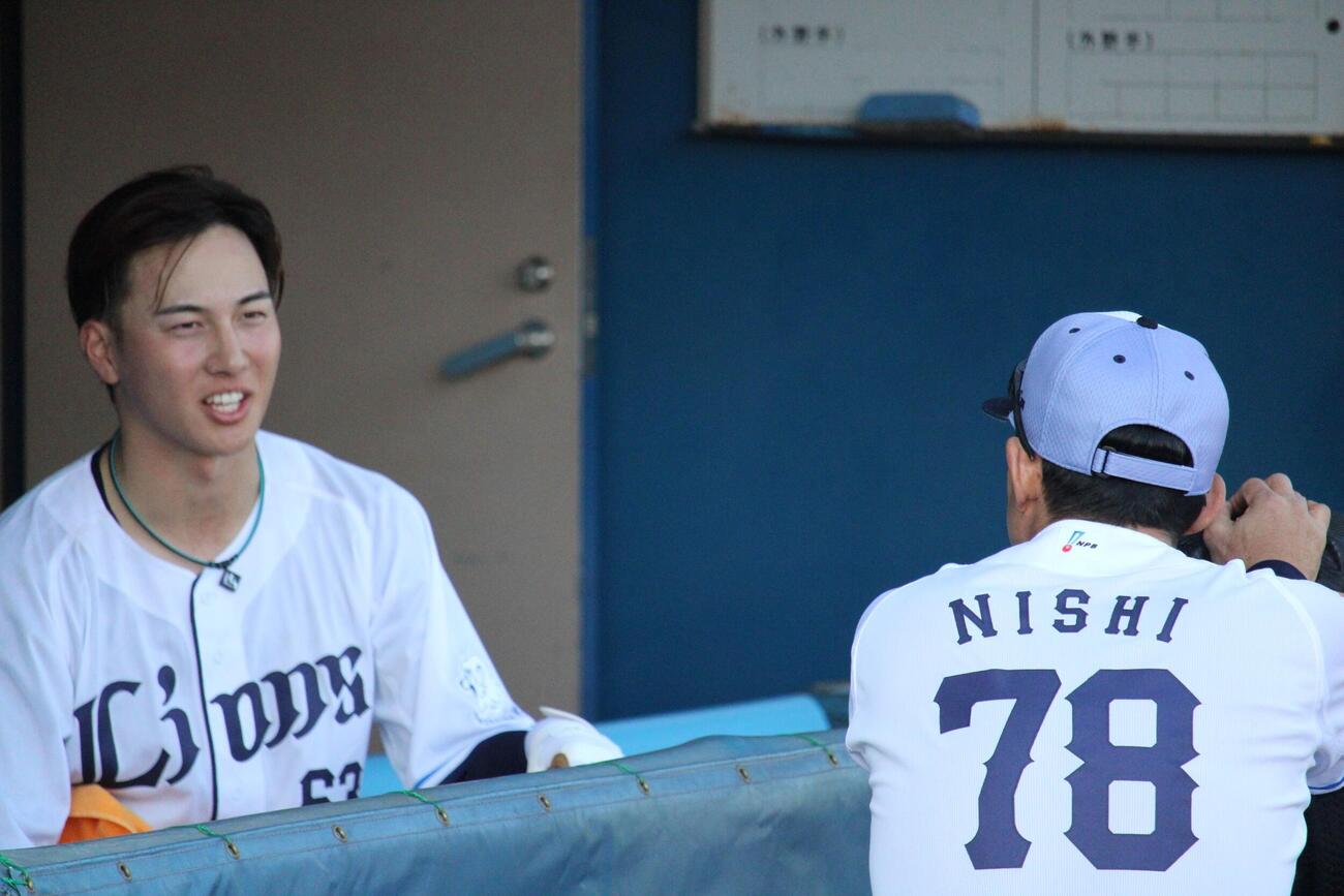 仁志野手チーフ兼打撃コーチ（右）と話をする西武長谷川（撮影・金子真仁）