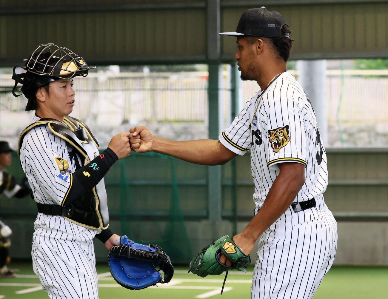 初のブルペン入りで投球練習を終えた阪神モレッタはボールを受けた梅野（左）とグータッチ（撮影・加藤哉）