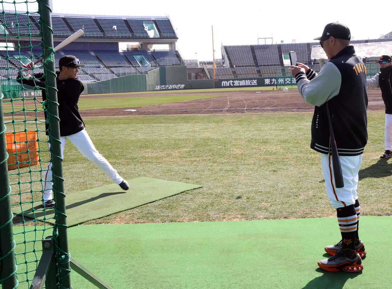 ロングティー打撃中、巨人坂本勇（左）は阿部監督から写メを撮られる（撮影・浅見桂子）