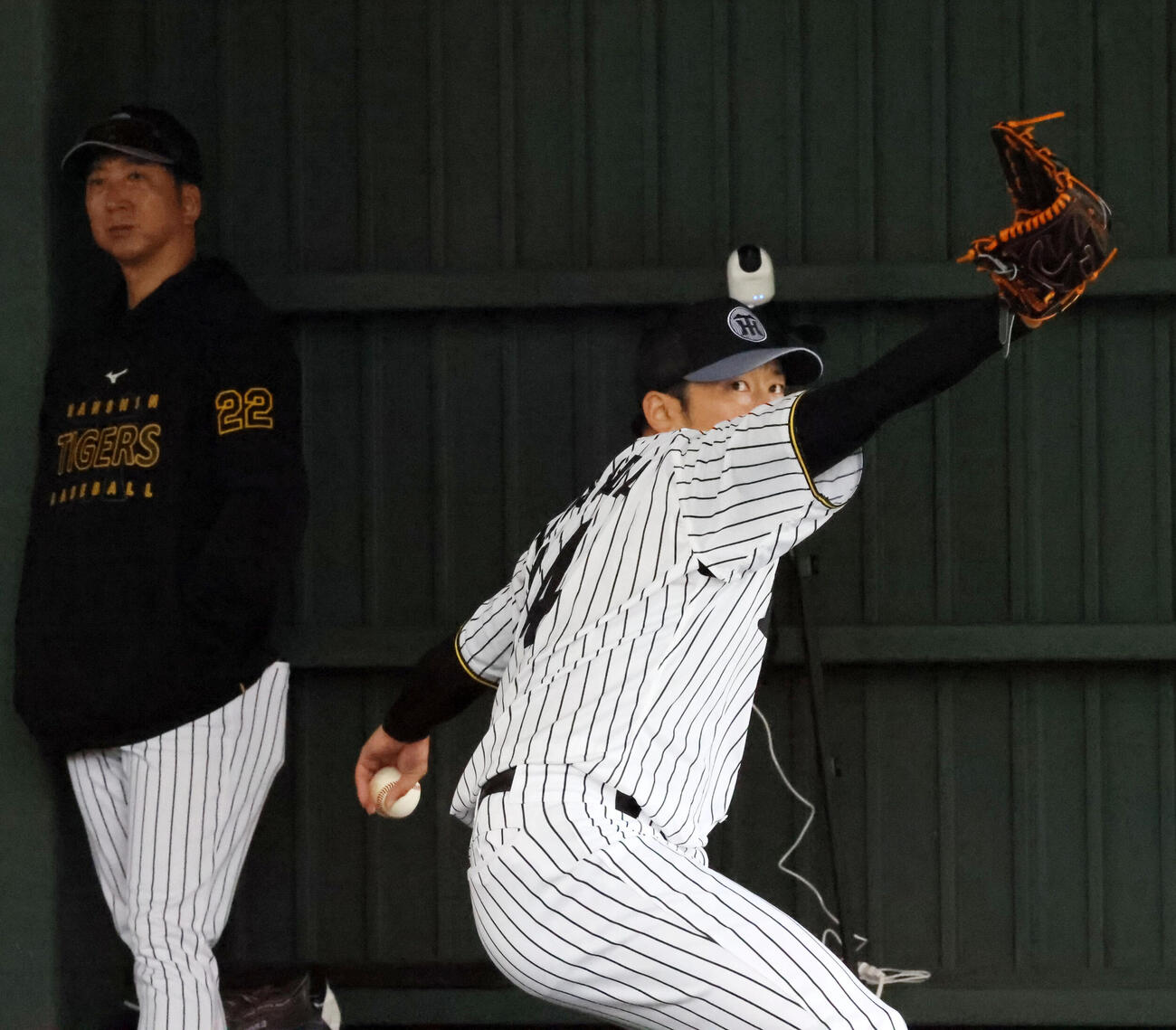 ブルペンで投球練習する阪神岩貞。左は藤川監督（撮影・加藤哉）