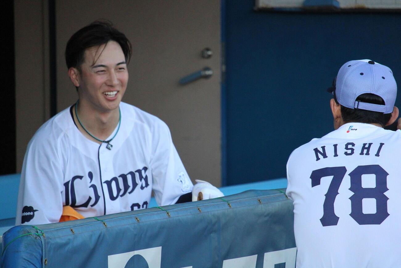 仁志野手チーフ兼打撃コーチ（右）と話をする西武長谷川（撮影・金子真仁）