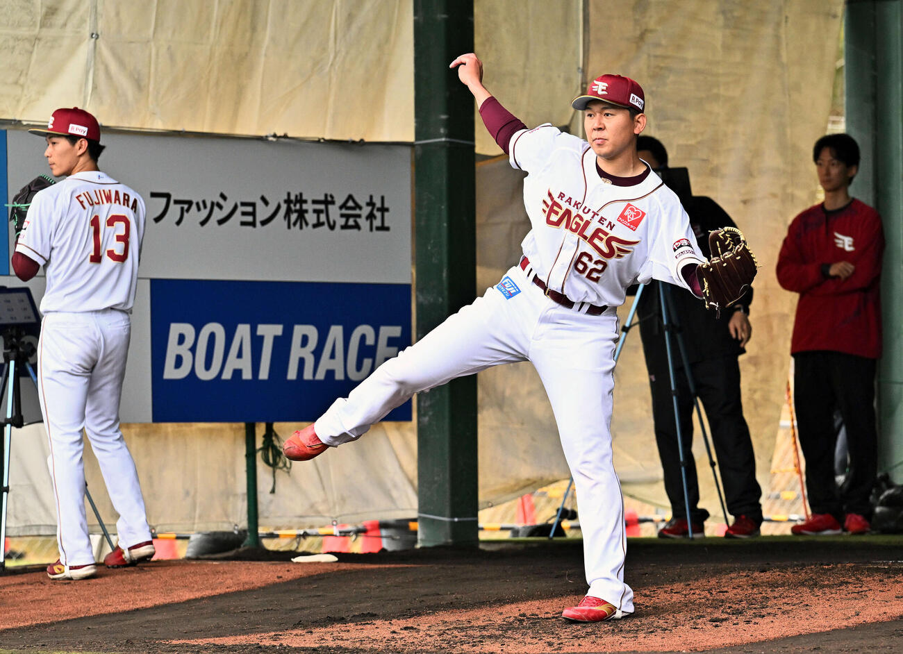 ブルペンで投球練習する楽天西口。後方は藤原（撮影・滝沢徹郎）