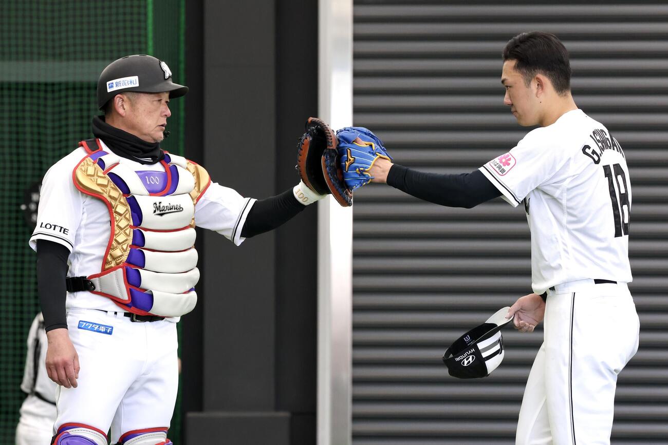 ブルペンでの投球を終えタッチを交わすロッテ石垣元（撮影・宮地輝）