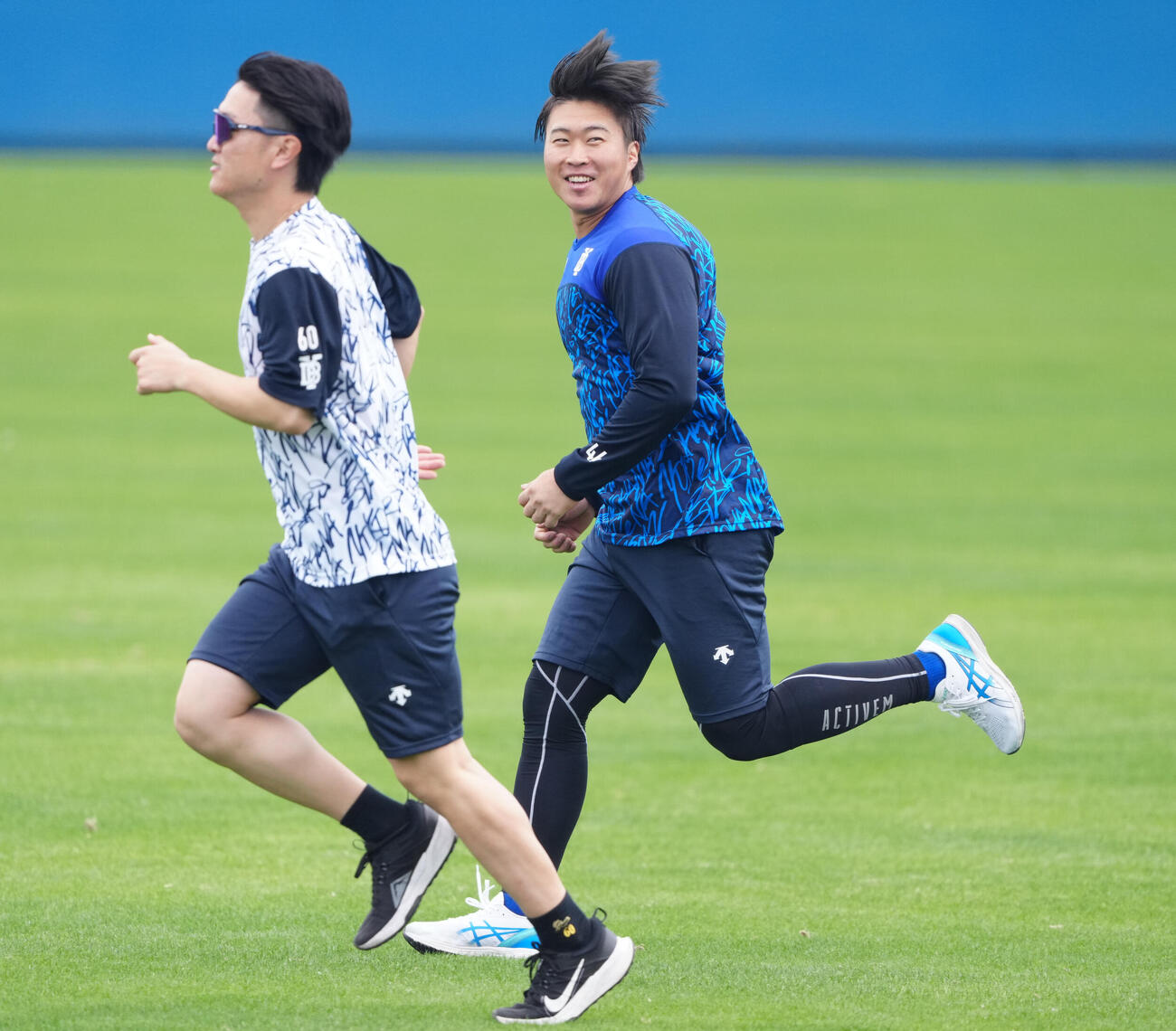 笑顔でランニングするDeNA石上。左は古市（撮影・鈴木みどり）