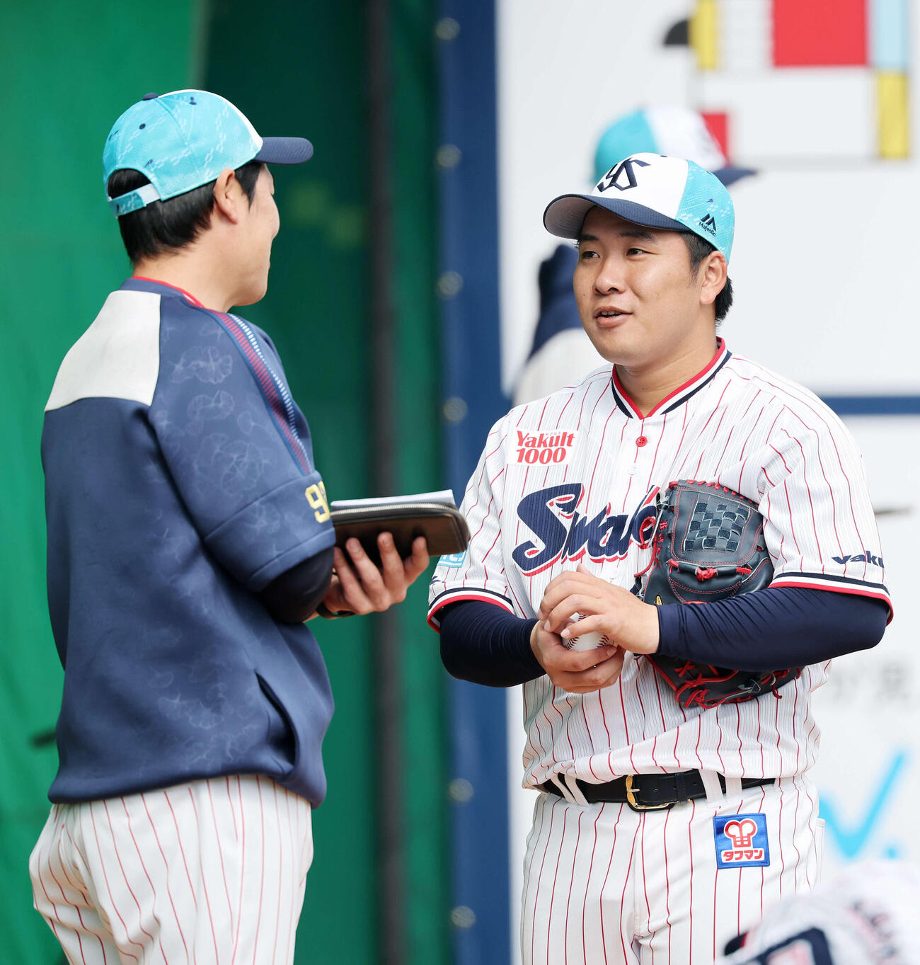 ブルペンで投球練習後、ヤクルト山本投手コーチ（左）と話す荘司（撮影・鈴木正人）　