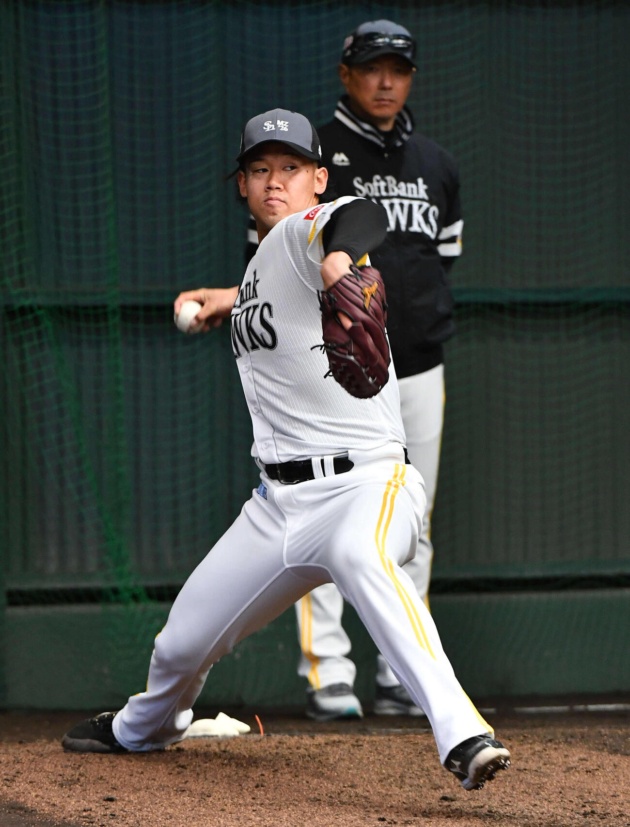 ブルペンで小久保監督（右）が見守る前で投げ込むソフトバンク稲川（撮影・岩下翔太）
