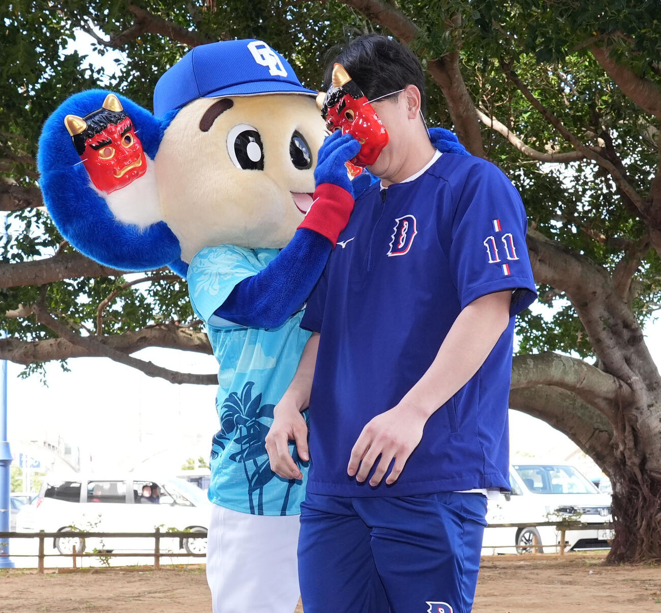 中日中西（右）は節分の豆まきで鬼役のドアラの反撃を受け鬼の面をつけられる（撮影・森本幸一）