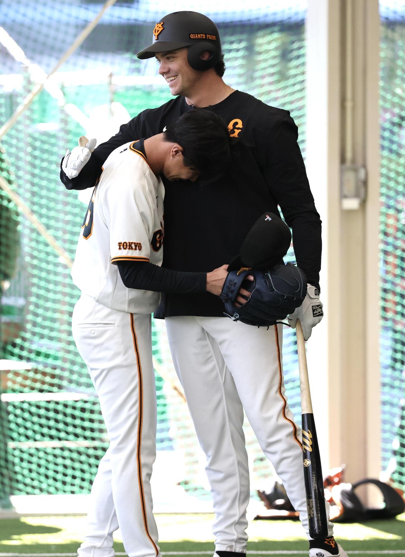 プルペンで巨人ダルベック(右)の足に投球を当て謝罪する山城(撮影・浅見桂子)