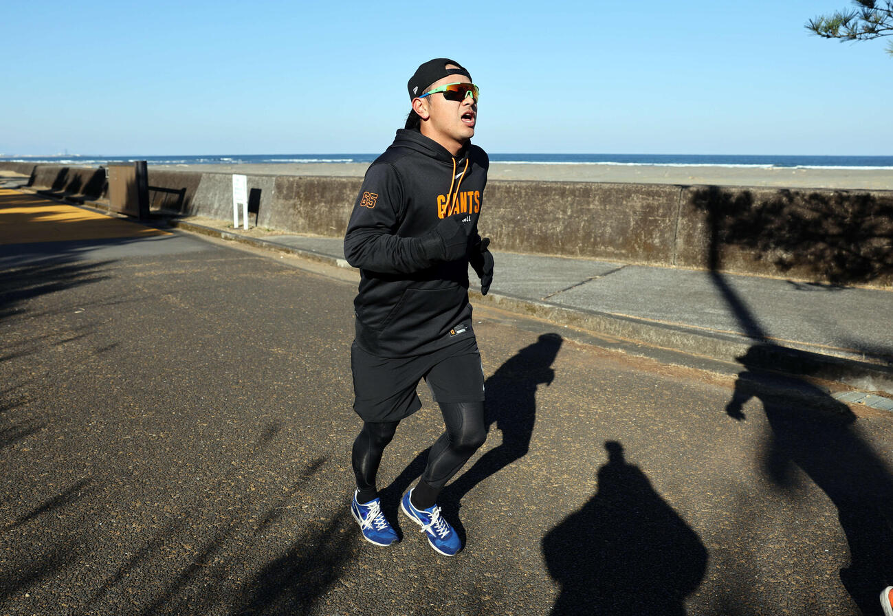 海を背に、宿まで走って帰る巨人石川（撮影・浅見桂子）