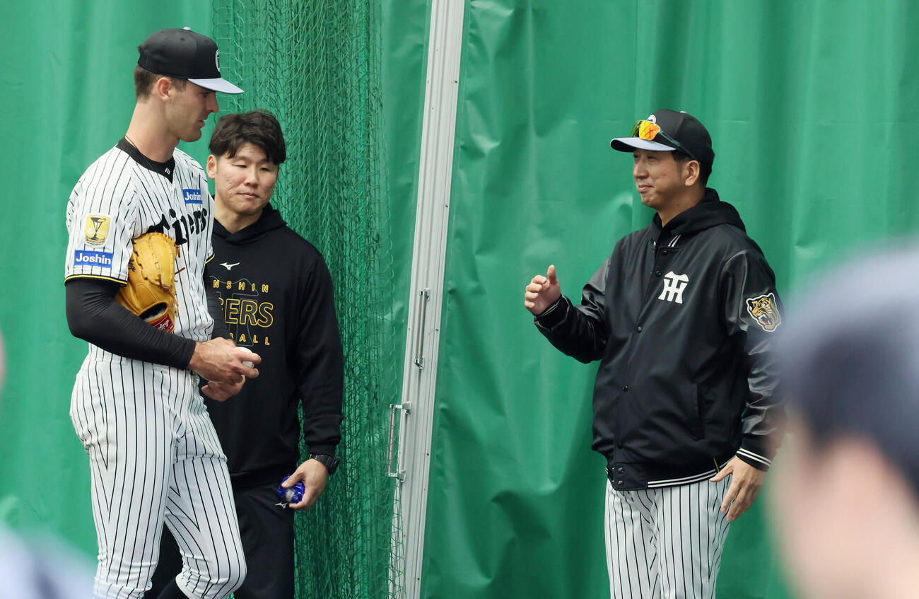 初めてブルペンに入って投球練習を行った阪神ラグズデール（左）は藤川監督と言葉をかわす（撮影・加藤哉）