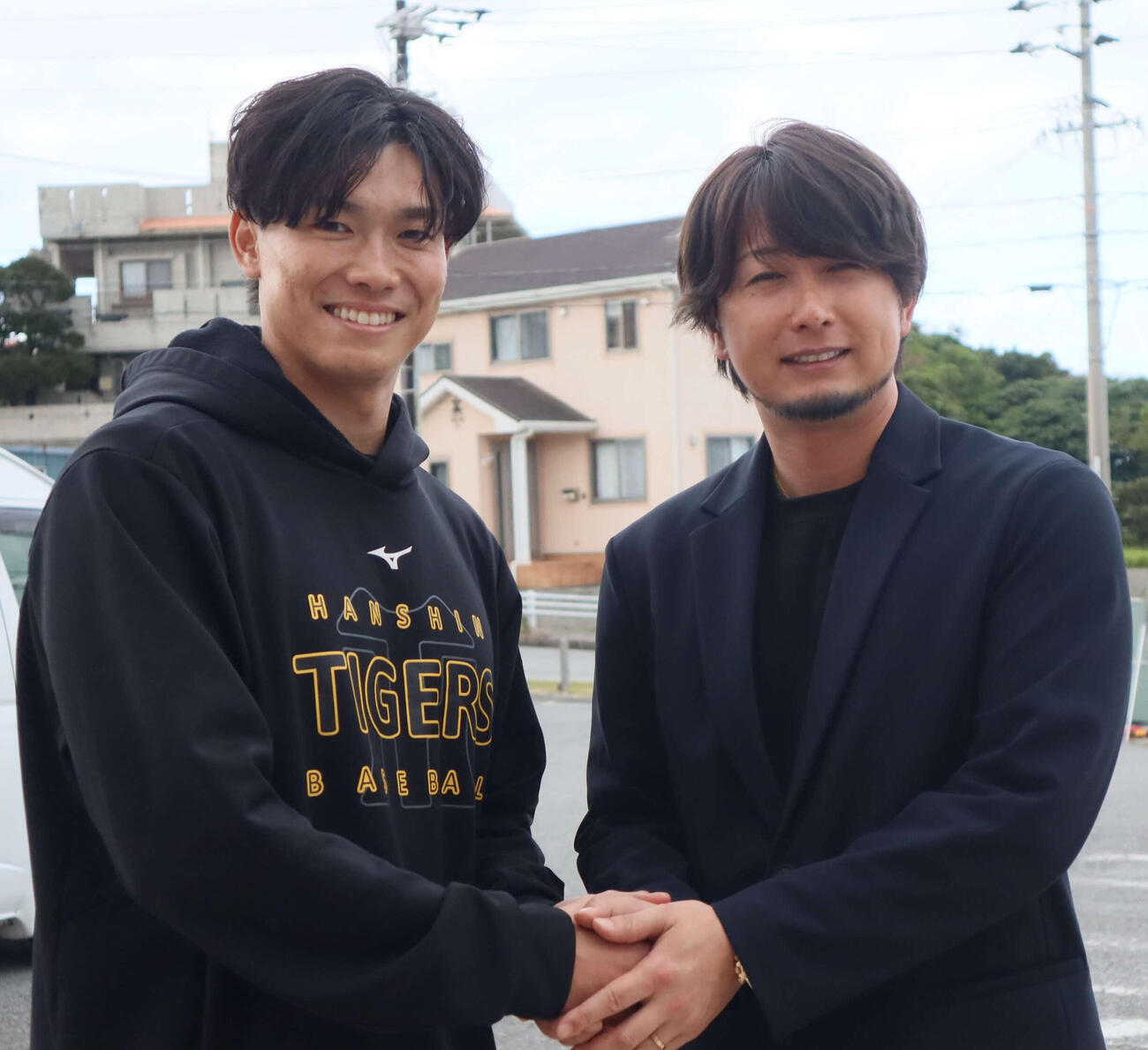 握手を交わす阪神湯浅（左）と元DeNA三嶋一輝氏（撮影・村松万里子）