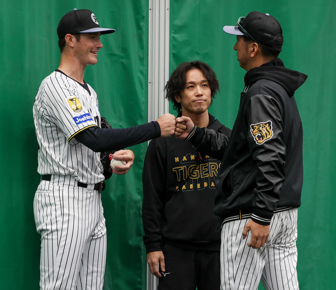 ブルペンで投球を終えた阪神ルーカス（左）とタッチをかわす藤川監督（撮影・上山淳一）