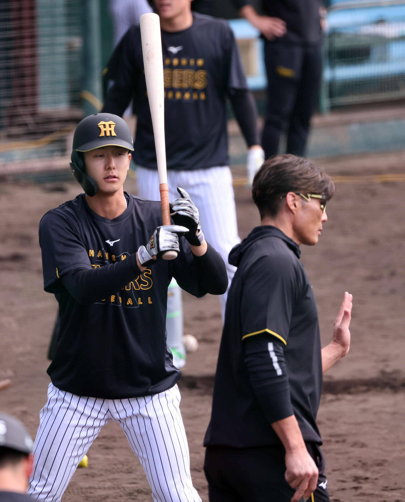 阪神小幡（左）は糸井SAの話を聞きながらティー打撃に取り組む（撮影・西尾就之）