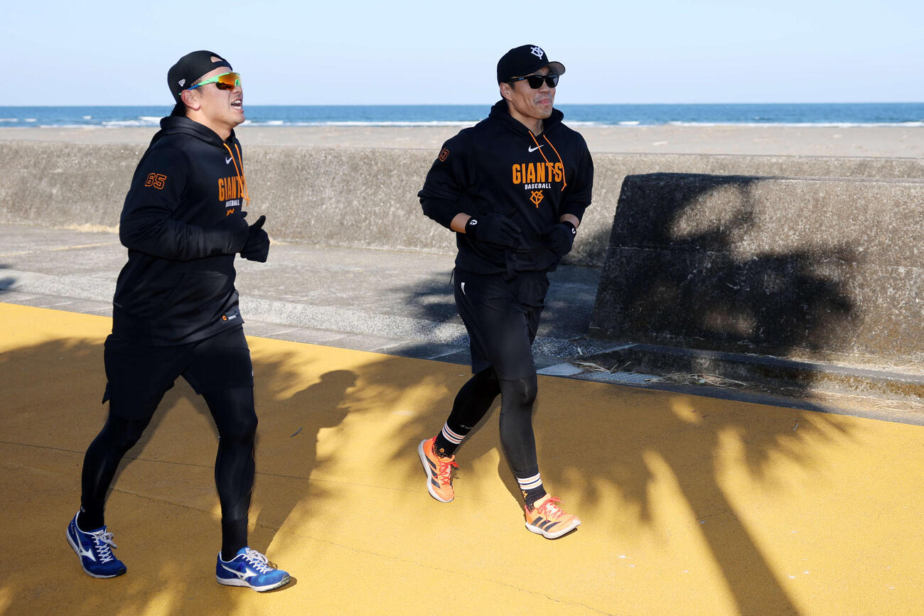 海を背に、ヤシの木の影の中、宿まで走って帰る巨人石川（左）と則本（撮影・浅見桂子）