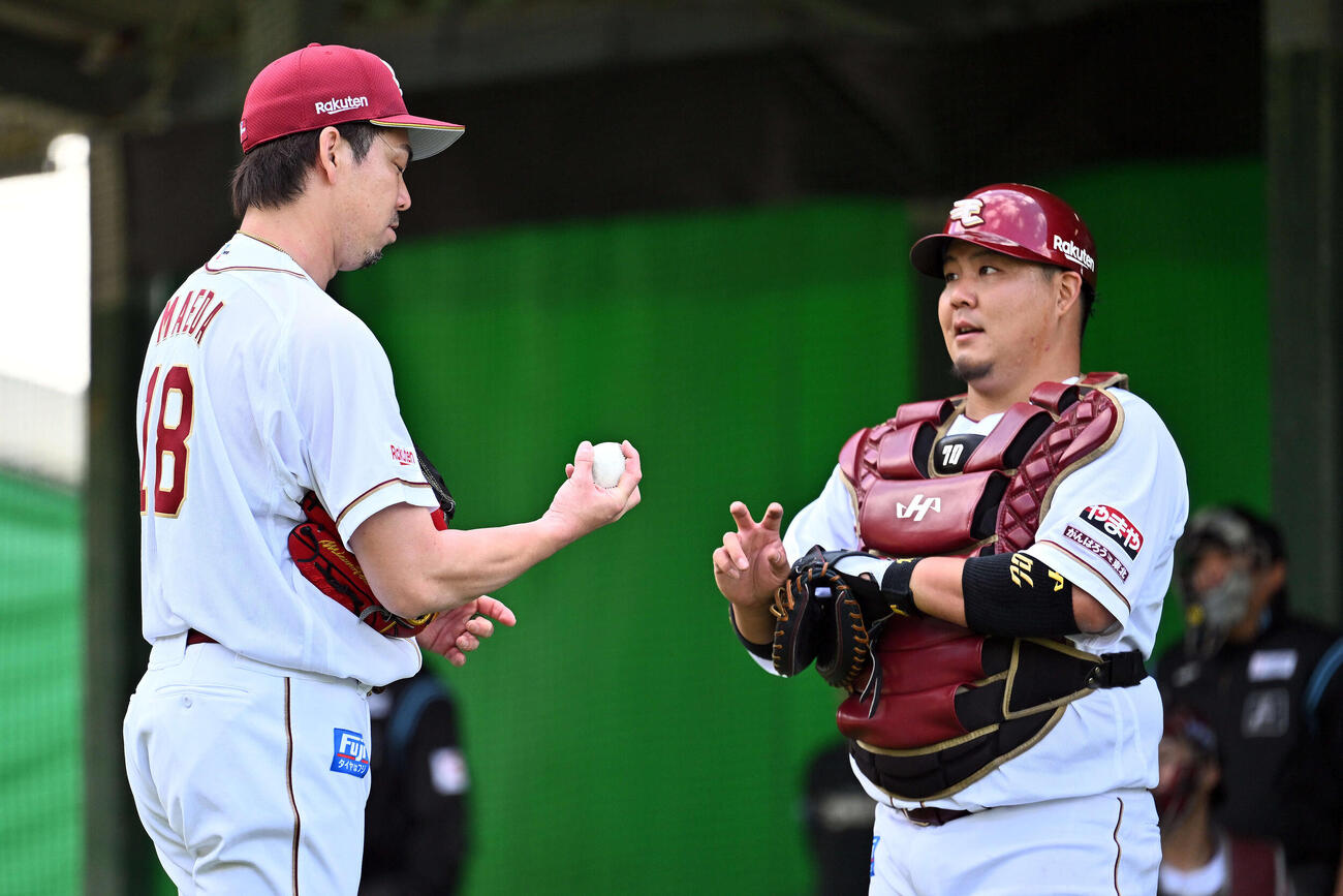 ブルペンの投球練習を終えた楽天前田健（左）は石原と話す（撮影・滝沢徹郎）