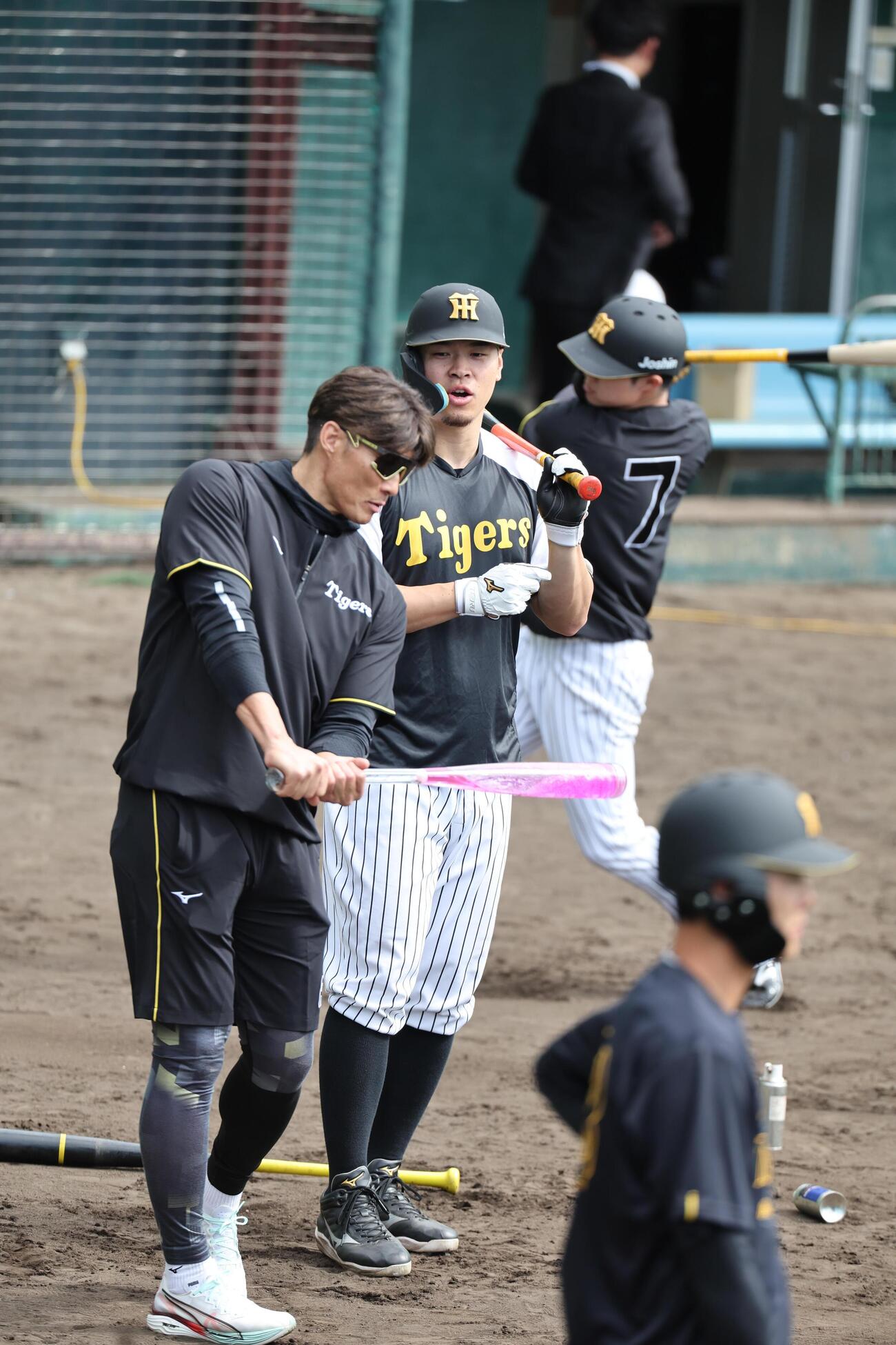 阪神キャンプで臨時コーチを務める糸井SA（左）は佐藤の前で自分が持ち込んだアクアバットを振ってみせる（撮影・西尾就之）