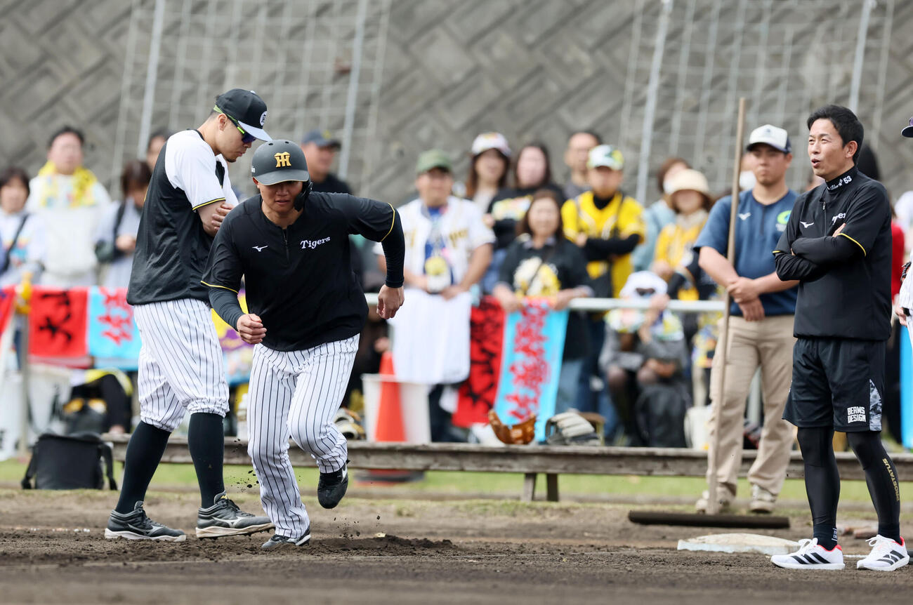 サブグラウンドで行われた阪神赤星臨時コーチ（右）による走塁練習で一塁からスタートする森下。左は佐藤（撮影・加藤哉）