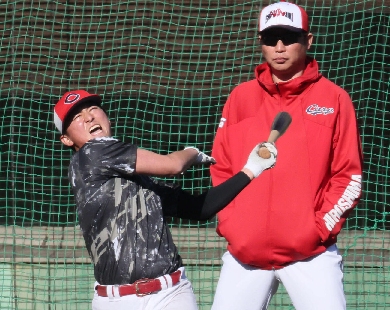 ロングティーをする広島佐々木と見守る新井貴浩監督（撮影・加藤孝規）