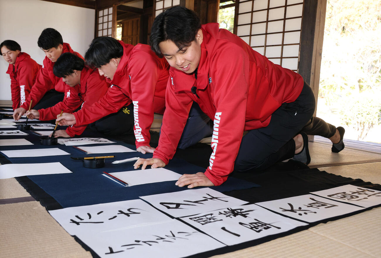 広島キャンプの休日、飫肥城近くの旧藩校振徳堂で書道に挑戦する新人選手ら。ドラフト1位の平川は目標より、左のドラフト2位の斉藤汰直（たいち）の名前を書くのに盛り上がる（撮影・加藤孝規）