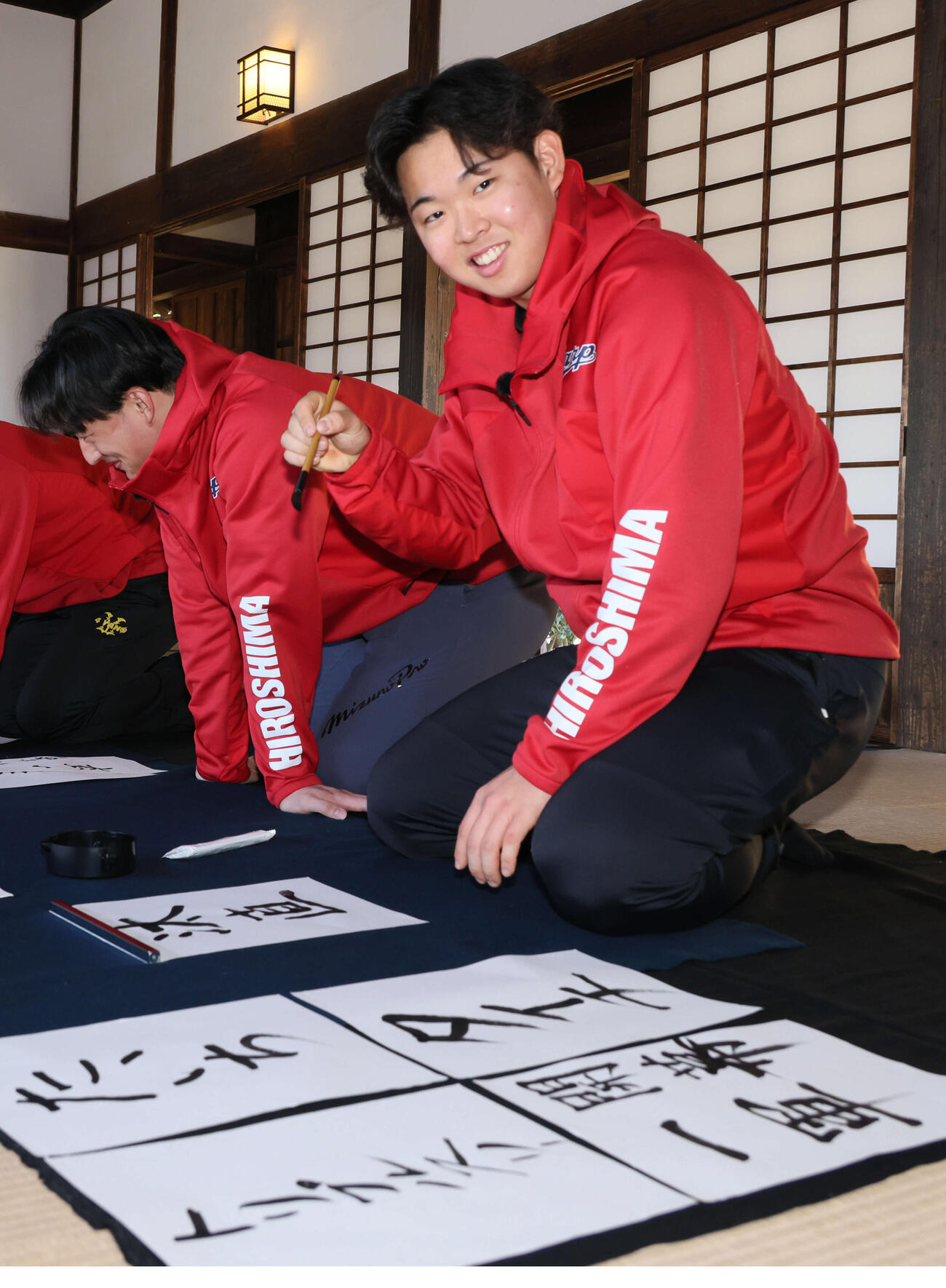 広島キャンプの休日、飫肥城近くの旧藩校振徳堂で書道に挑戦する新人選手ら。ドラフト1位の平川は目標より、左のドラフト2位の斉藤汰直（たいち）の名前を書くのに盛り上がる（撮影・加藤孝規）