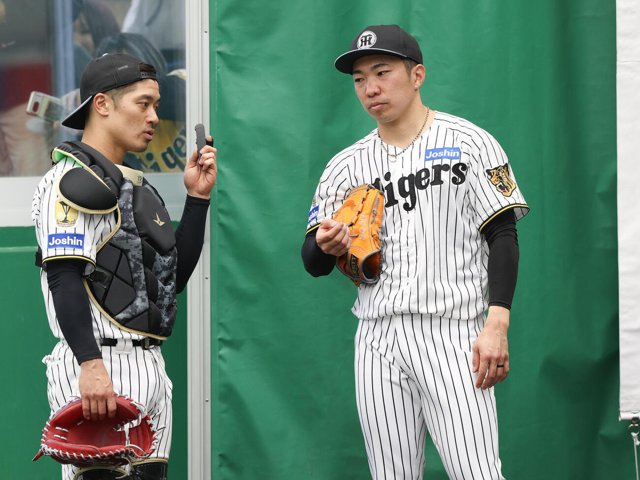 ピッチコムを使って投球した阪神石井（右）と話し込む坂本（撮影・上山淳一）