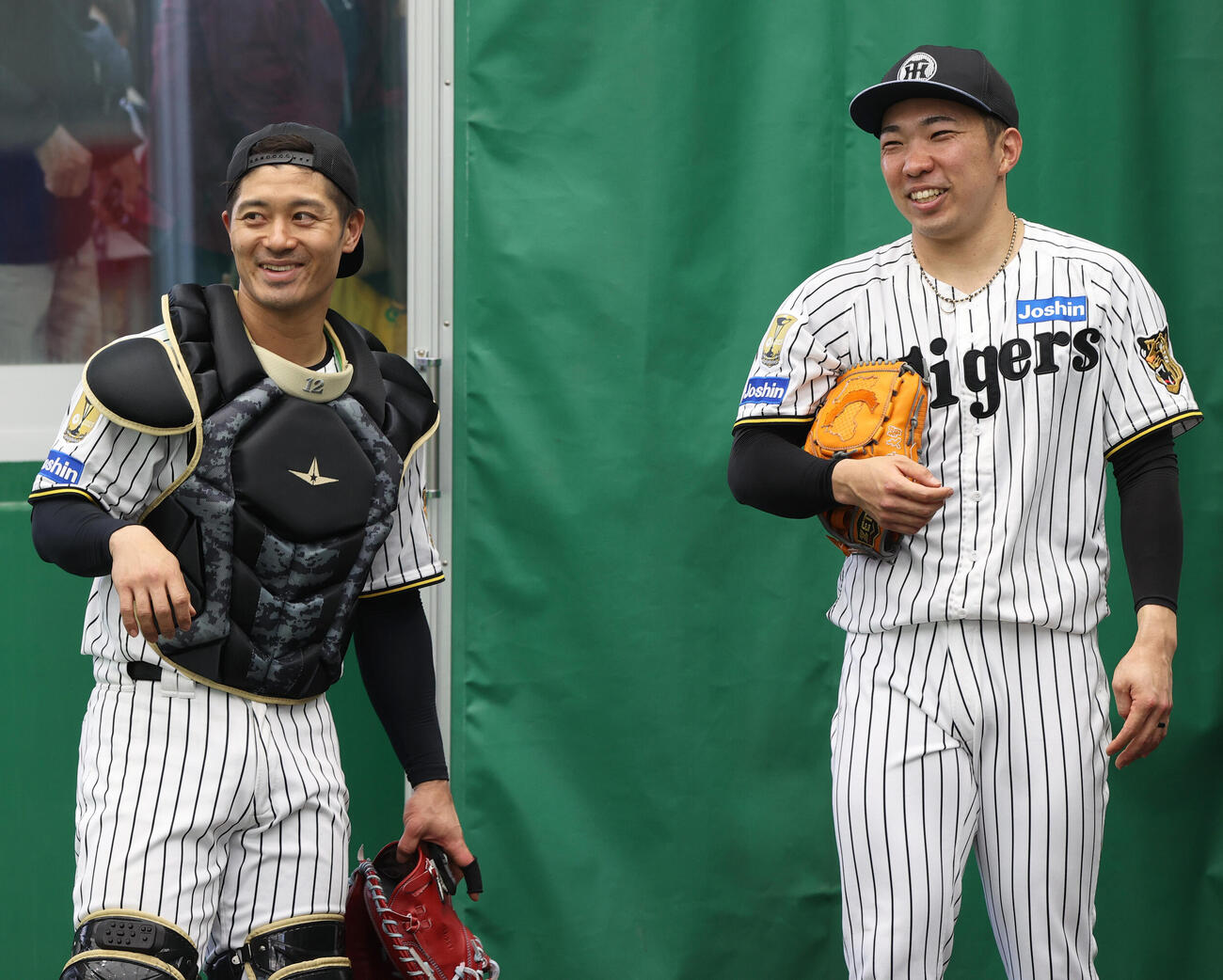 阪神石井（右）は坂本とピッチコムのサイン伝達を確認し笑顔を見せる（撮影・上山淳一）
