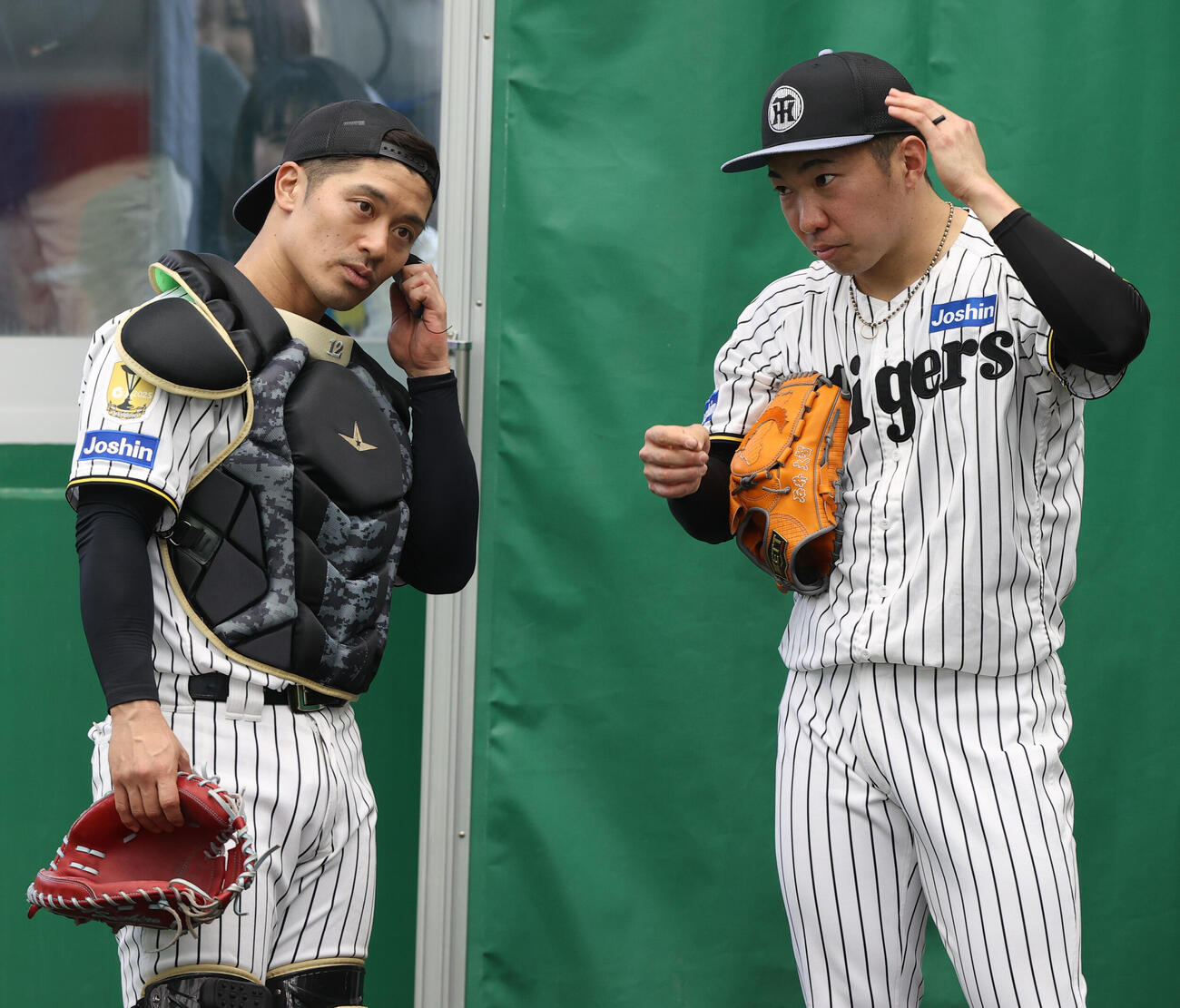ピッチコムを使って投球した阪神石井（右）と話し込む坂本（撮影・上山淳一）