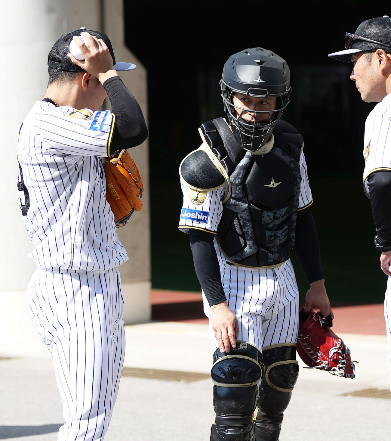 阪神坂本（中央）は石井（左）とピッチコムのサイン伝達を確認する（撮影・上山淳一）
