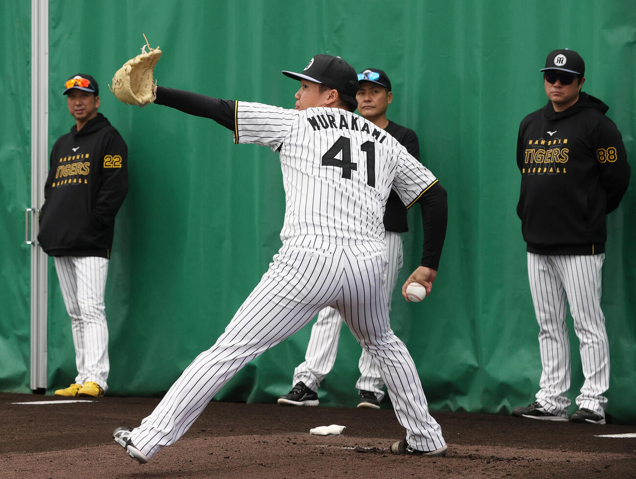 阪神村上（手前）は藤川監督（左）が見守る中、投球する（撮影・上山淳一）