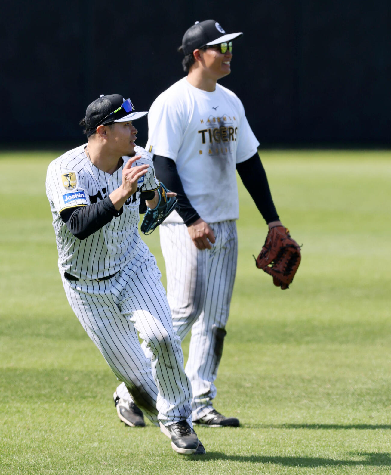 打撃練習中、中堅で打球を捕球する阪神佐藤輝（左）と森下（撮影・加藤哉）