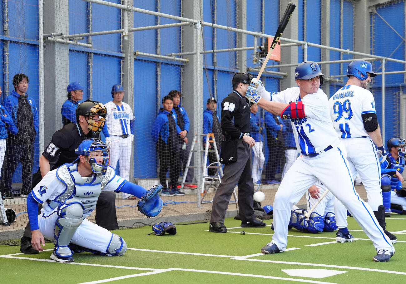 ブルペンで山崎の投球を受けるDeNA相川監督。右は牧（撮影・鈴木みどり）