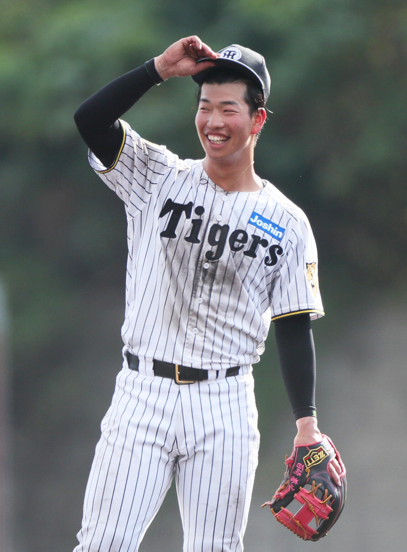 サブグラウンドで笑顔を見せる阪神百崎（撮影・上山淳一）