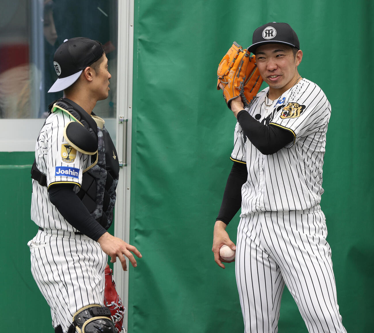 阪神石井（右）は坂本とピッチコムのサイン伝達を確認する（撮影・上山淳一）