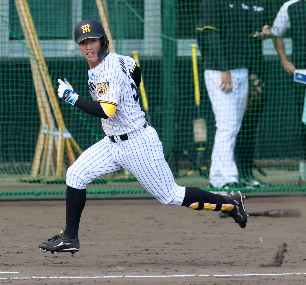 シート打撃練習で外野へ飛球を打ち上げ駆け出す阪神百崎（撮影・加藤哉）