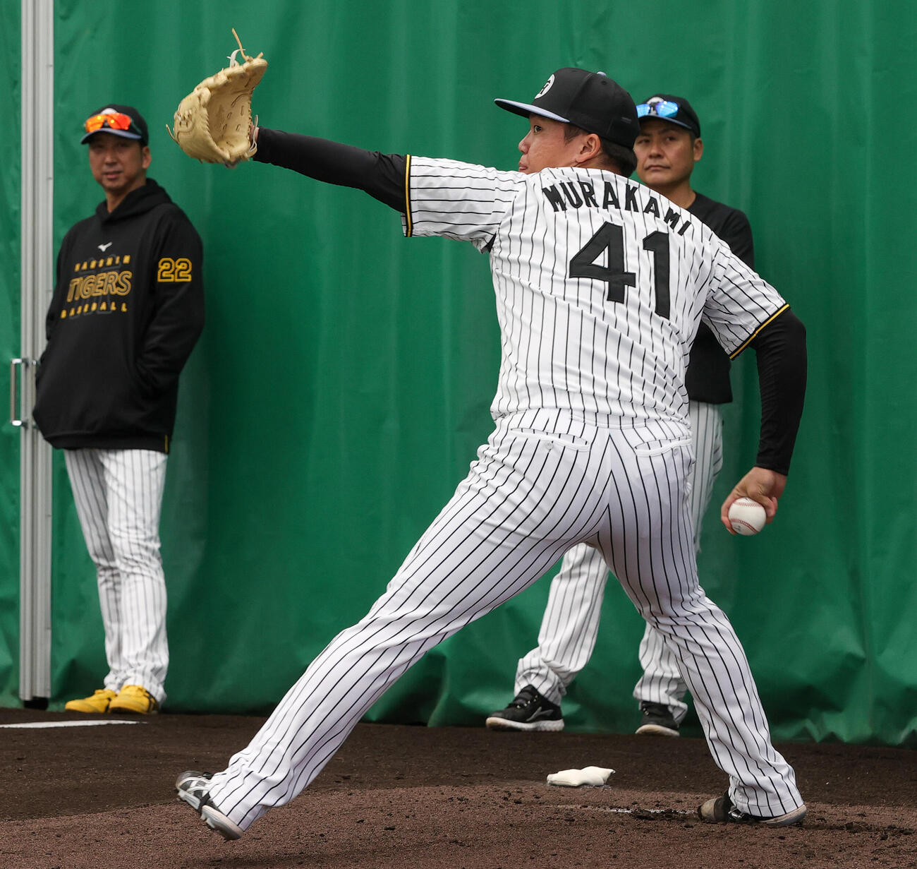 阪神村上（手前）は藤川監督が見守る中、投球する（撮影・上山淳一）