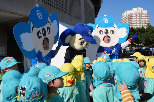 園児たちとドアラの面をつけた先生たちに囲まれるドアラ（撮影・森本幸一）
