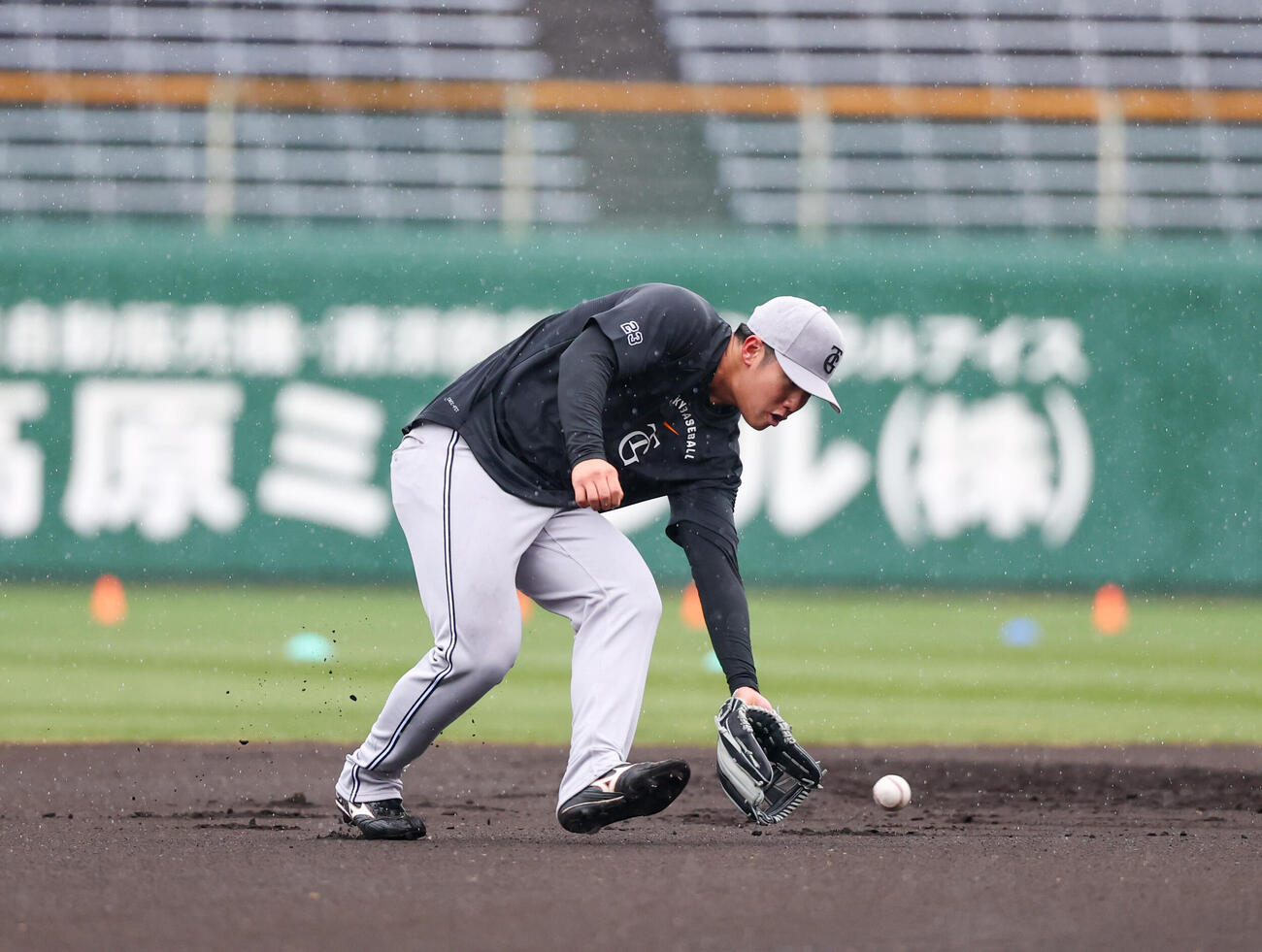 早出で雨の中守備練習をする巨人石塚（撮影・増田悦実）