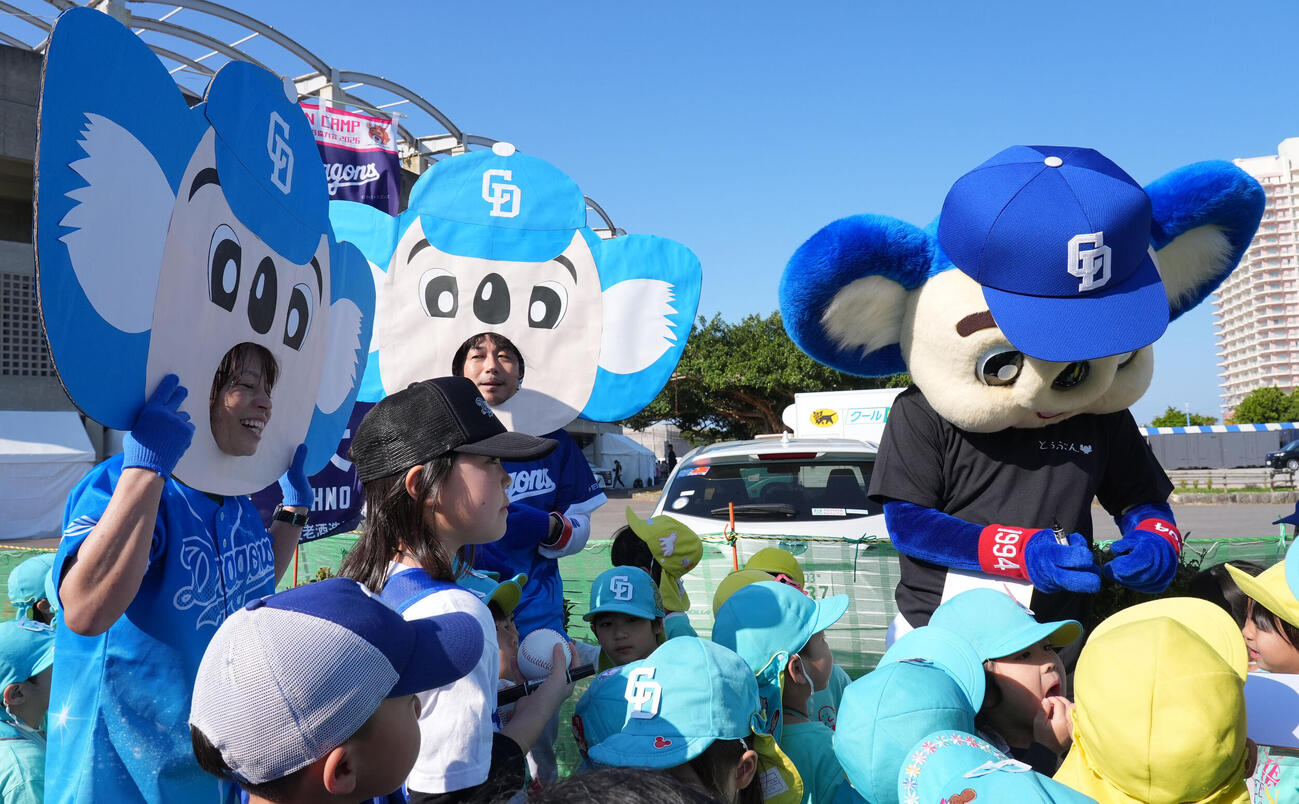 園児たちとドアラの面をつけた先生たちに囲まれるドアラ（撮影・森本幸一）