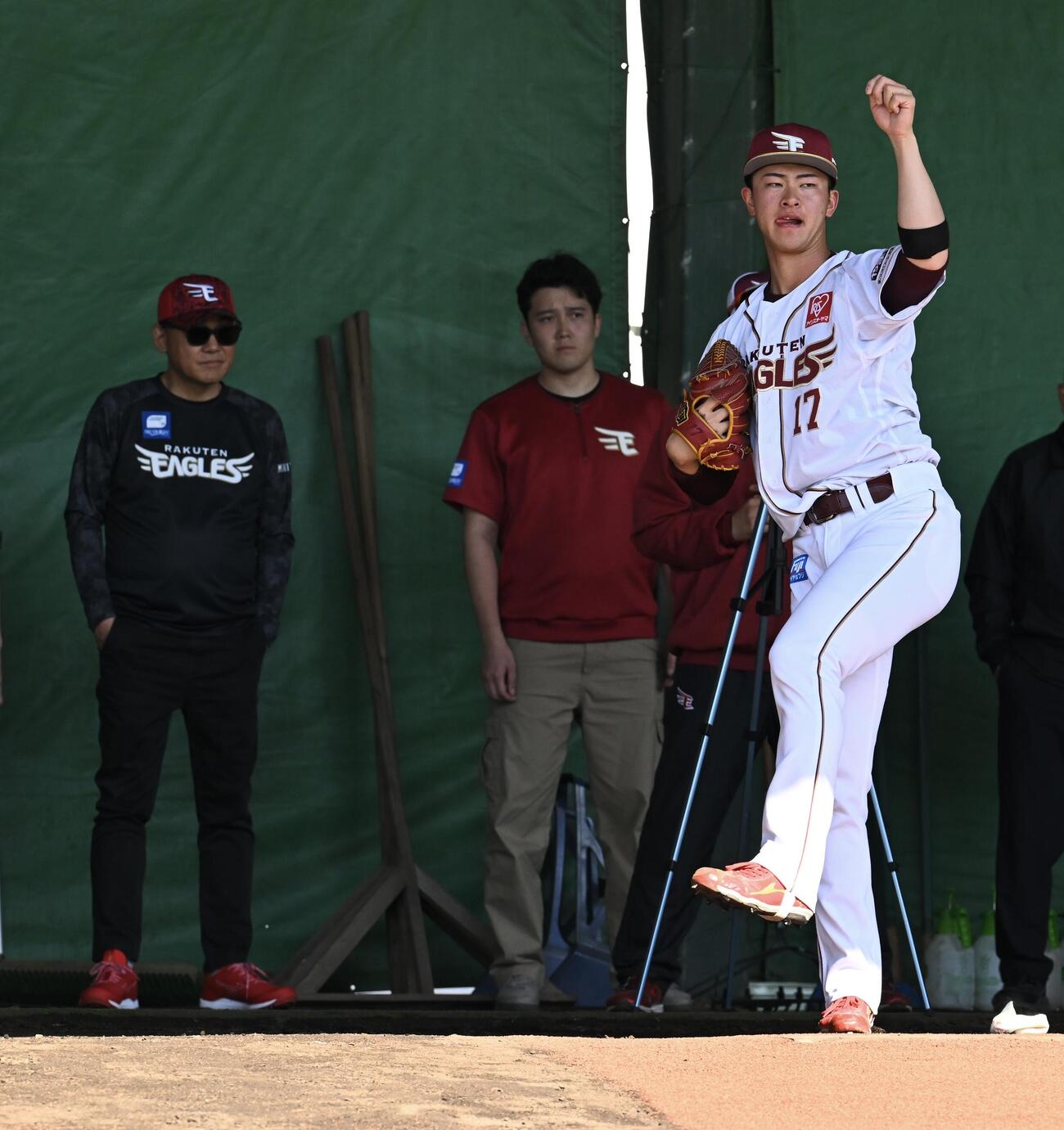 楽天三木谷浩史オーナー（後方左）に見守られブルペンで投球練習する古謝（撮影・滝沢徹郎）