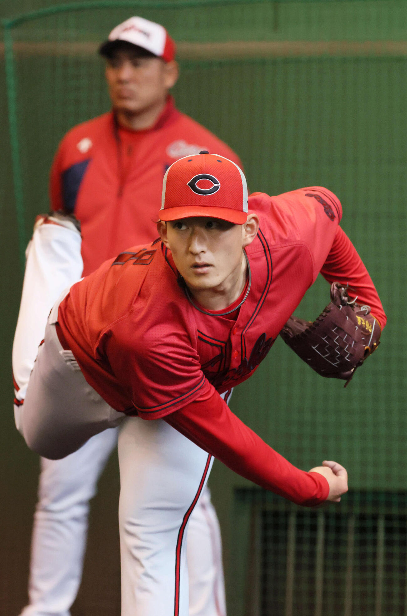 ブルペンで投げる広島ドラフト2位の斉藤汰。後ろは菊地原投手コーチ（撮影・加藤孝規）
